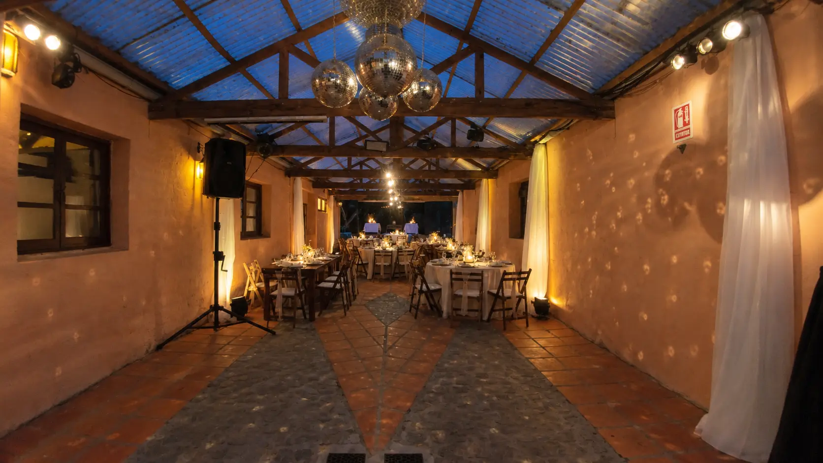 Salón montado con bolas de espejo y mesas servidas