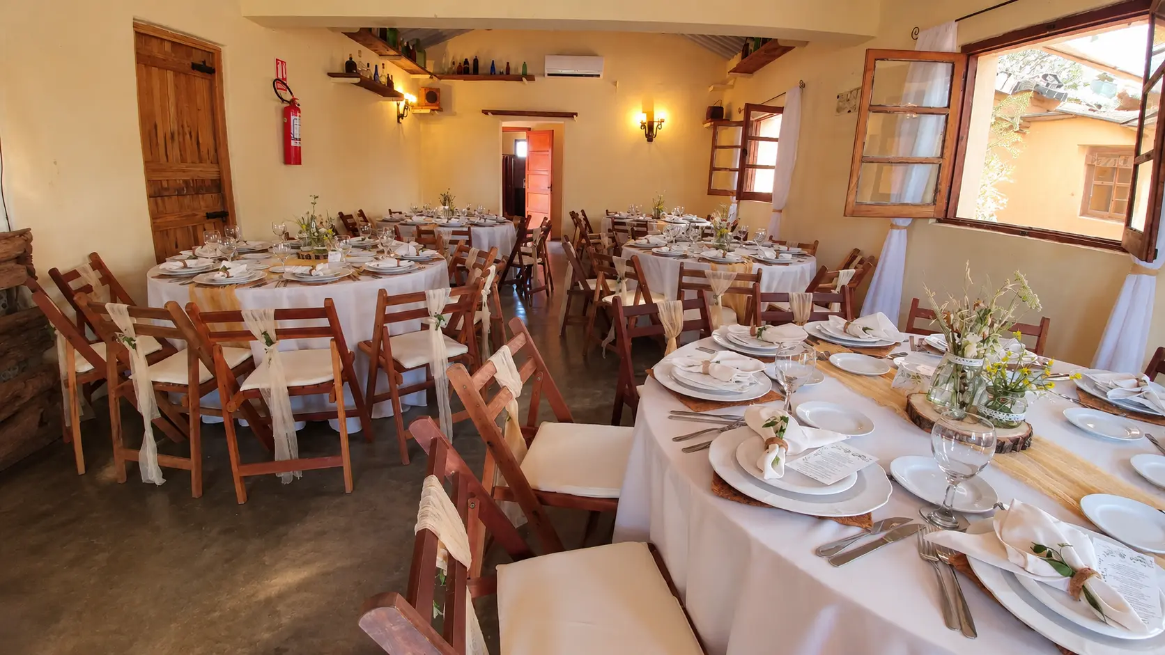 Salón con mesas redondas y sillas de madera